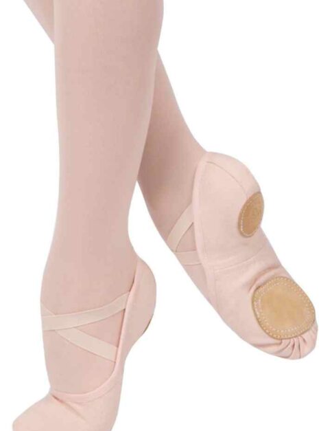 Close-up van voeten in zachte balletschoenen, gelabeld "Dream Stretch Grishko Preferred by Dancers Worldwide", tegen een lichte achtergrond. Tekst links benadrukt comfort en elasticiteit, perfect voor het bereiken van sierlijke bewegingen.