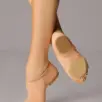 Een persoon die beige jazzschoenen draagt, poseert met één voet in spitsstand en de andere plat op de grond, waarbij de zool en de pasvorm van de schoenen goed te zien zijn tegen een effen achtergrond.
